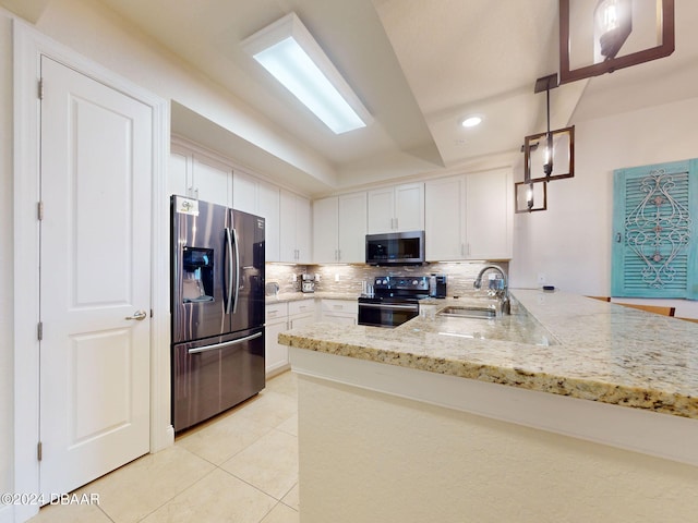 kitchen with stainless steel appliances, sink, kitchen peninsula, hanging light fixtures, and white cabinets