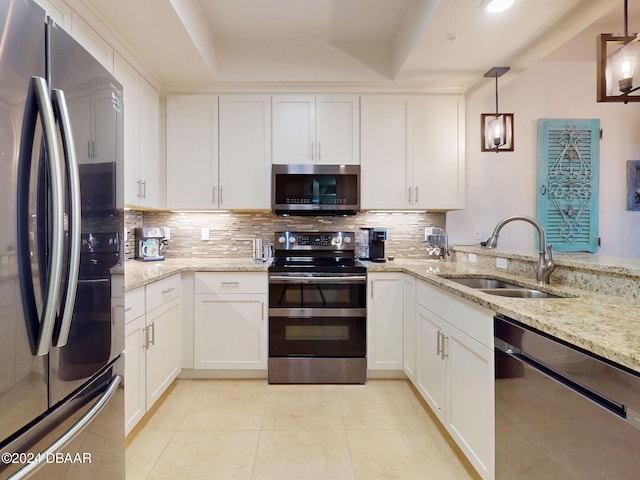 kitchen featuring hanging light fixtures, white cabinets, sink, and appliances with stainless steel finishes