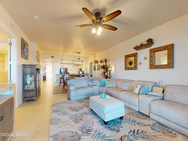 living room featuring ceiling fan with notable chandelier and light tile patterned floors