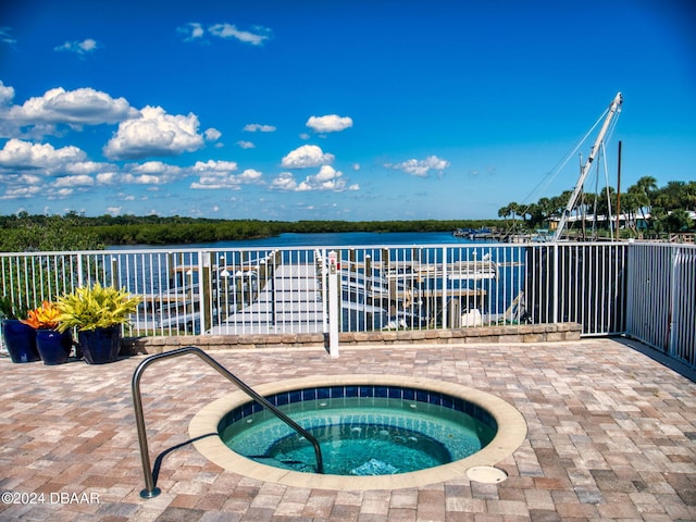 view of pool featuring a hot tub and a water view