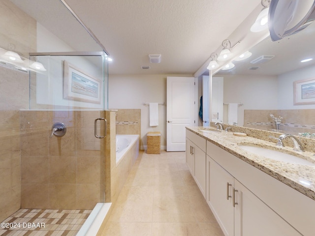 bathroom with shower with separate bathtub, a textured ceiling, tile patterned floors, and vanity