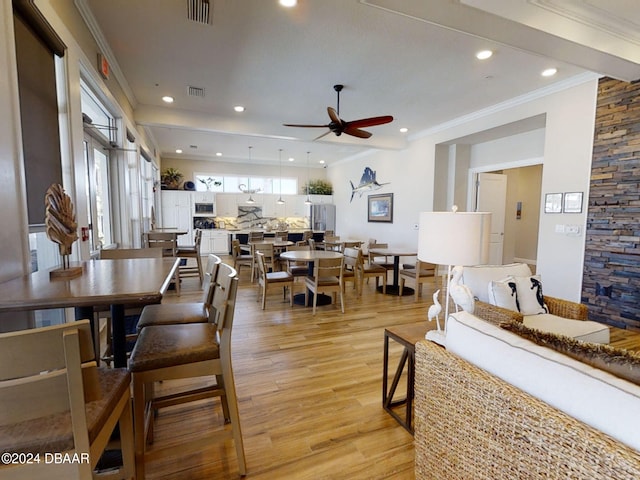 dining area with ornamental molding, ceiling fan, and light hardwood / wood-style floors