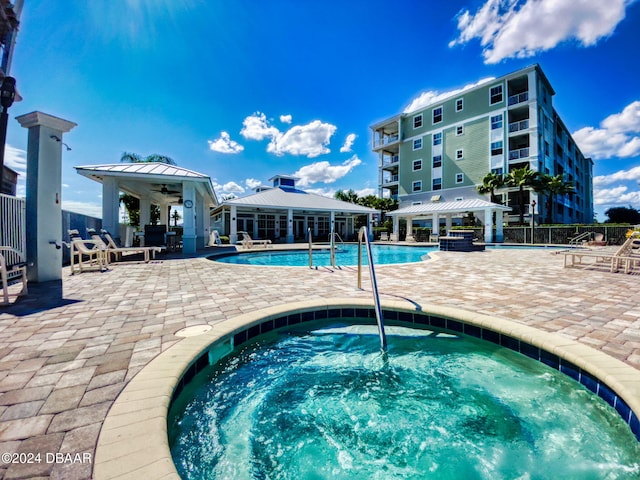 view of swimming pool featuring a hot tub and a patio