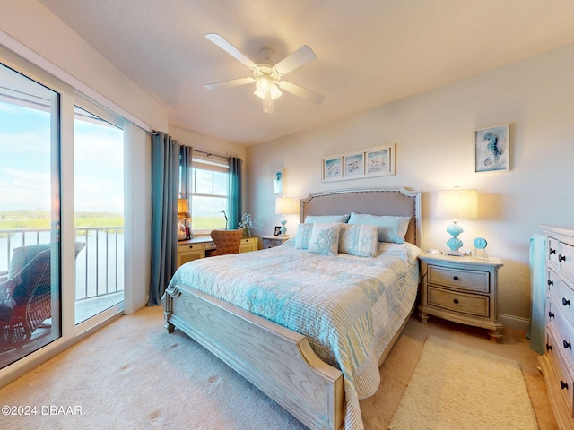 carpeted bedroom featuring ceiling fan, a water view, and access to outside