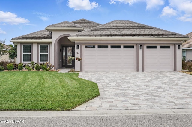 126 Briargate Look, Ormond Beach, FL 32174 - view of front facade with decorative driveway, a garage, a front lawn, and stucco siding