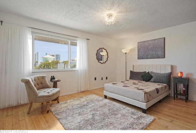 bedroom featuring hardwood / wood-style floors and a textured ceiling