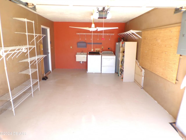 garage with a garage door opener, sink, and independent washer and dryer