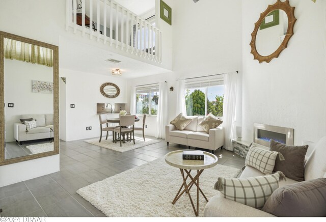 living room featuring a towering ceiling and dark tile patterned flooring