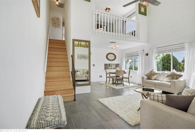 living room featuring a towering ceiling and ceiling fan