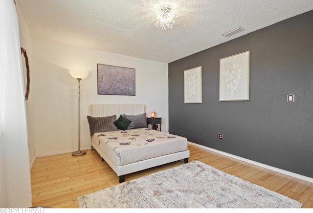 bedroom featuring wood-type flooring and a textured ceiling