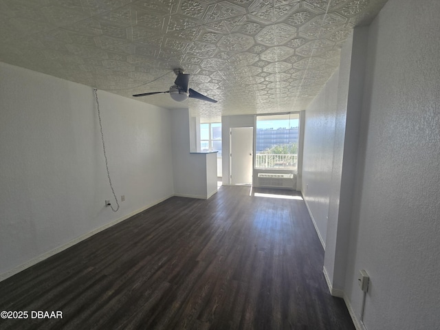 unfurnished living room featuring dark hardwood / wood-style flooring, a wall unit AC, and ceiling fan