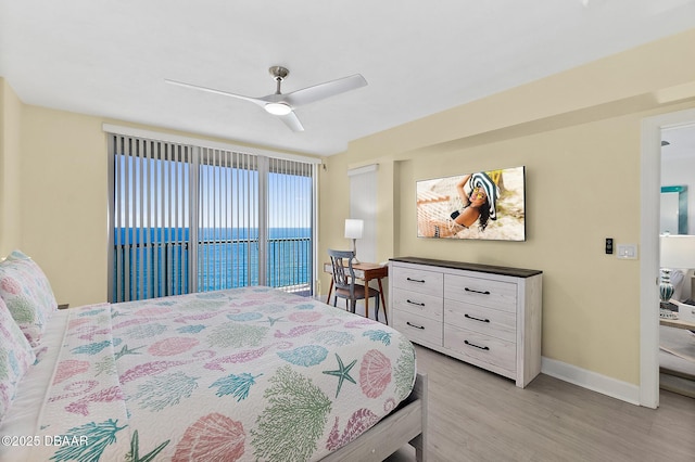 bedroom featuring baseboards, light wood-style flooring, ceiling fan, and access to exterior