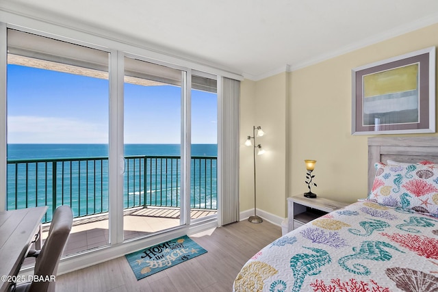 bedroom with wood finished floors, ornamental molding, baseboards, a water view, and access to outside