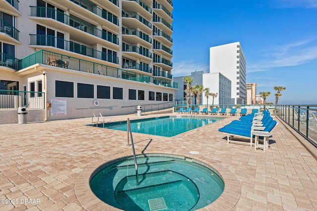 pool with a community hot tub, fence, and a patio