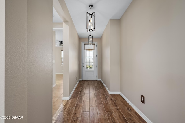 doorway to outside featuring ceiling fan with notable chandelier