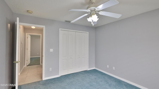 unfurnished bedroom featuring ceiling fan, a closet, and carpet