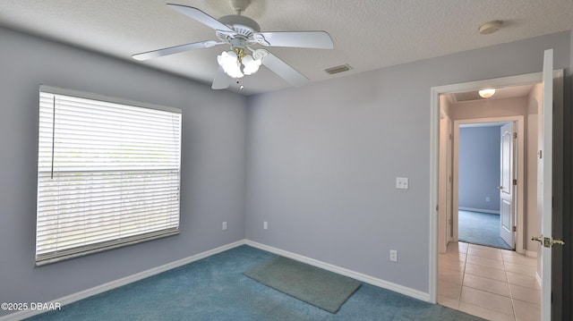 carpeted empty room featuring ceiling fan and a textured ceiling