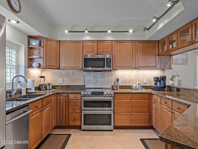 5300 S Atlantic Ave Unit 6-301, New Smyrna Beach, FL 32169 - kitchen with appliances with stainless steel finishes, a sink, brown cabinets, and decorative backsplash