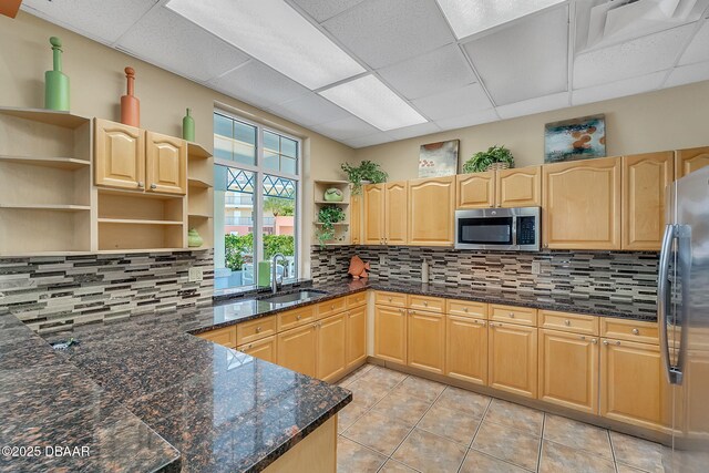 5300 S Atlantic Ave Unit 6-301, New Smyrna Beach, FL 32169 - kitchen featuring appliances with stainless steel finishes, open shelves, a sink, light brown cabinetry, and a paneled ceiling