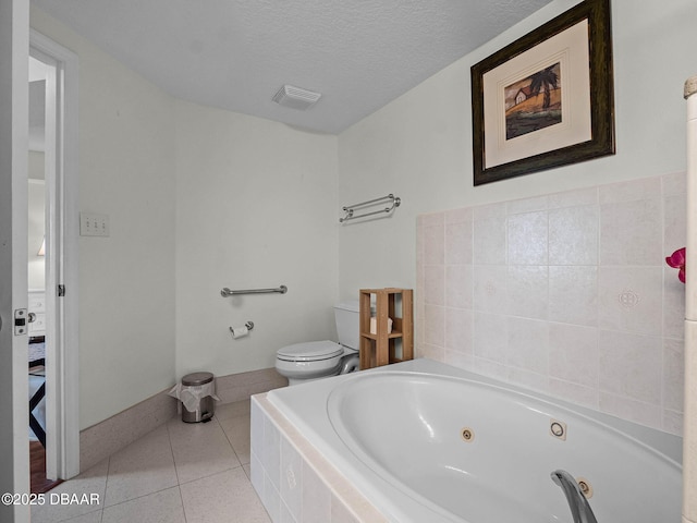 5300 S Atlantic Ave Unit 6-301, New Smyrna Beach, FL 32169 - full bathroom featuring a tub with jets, toilet, tile patterned flooring, and a textured ceiling