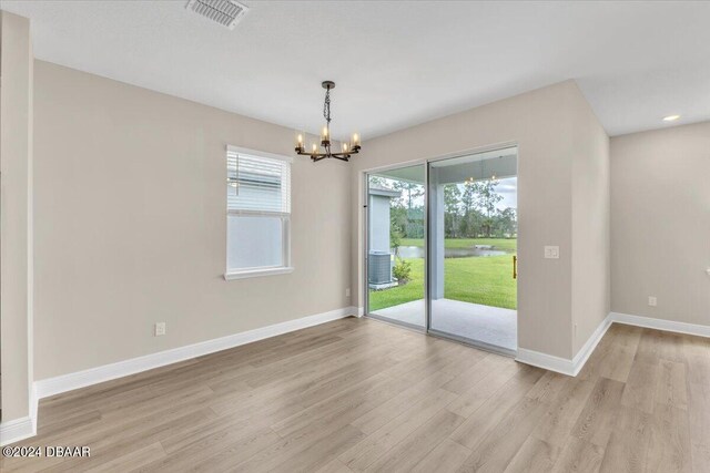 3116 Legends Preserve Dr, Daytona Beach, FL 32124 - unfurnished dining area with a chandelier, light wood-style flooring, baseboards, and a water view