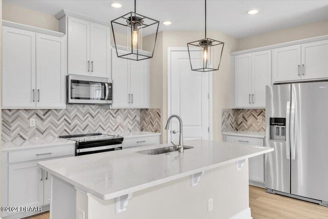 3116 Legends Preserve Dr, Daytona Beach, FL 32124 - kitchen featuring appliances with stainless steel finishes, a sink, white cabinets, a kitchen island with sink, and decorative backsplash