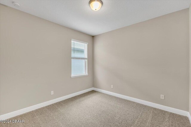 3116 Legends Preserve Dr, Daytona Beach, FL 32124 - spare room with carpet, baseboards, and a smoke detector
