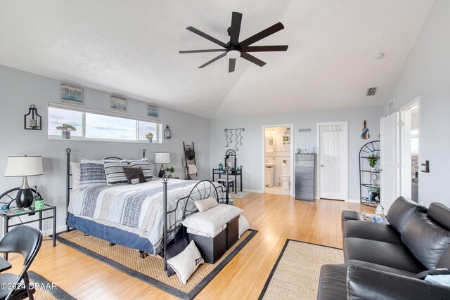 bedroom with connected bathroom, light hardwood / wood-style flooring, ceiling fan, and vaulted ceiling