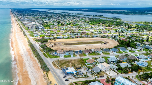 drone / aerial view featuring a water view and a view of the beach