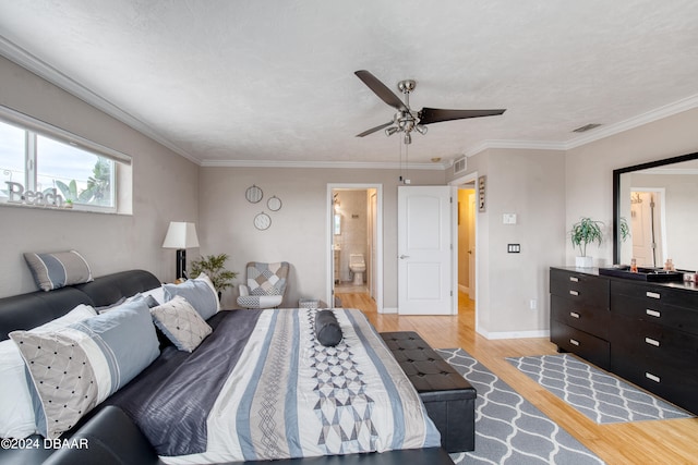 bedroom featuring light wood-type flooring, ceiling fan, ornamental molding, and connected bathroom