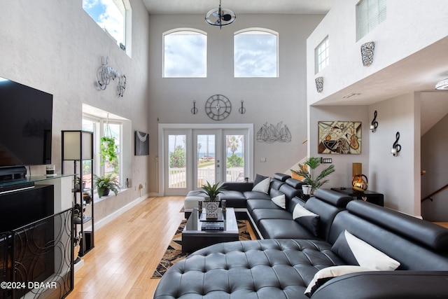 living room featuring light wood-type flooring and a high ceiling