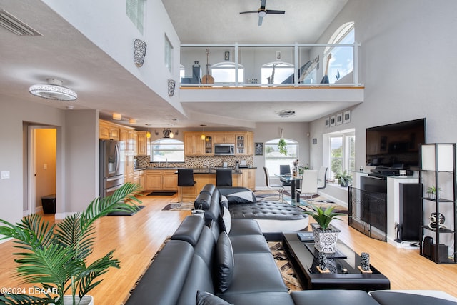 living room with light hardwood / wood-style floors and ceiling fan