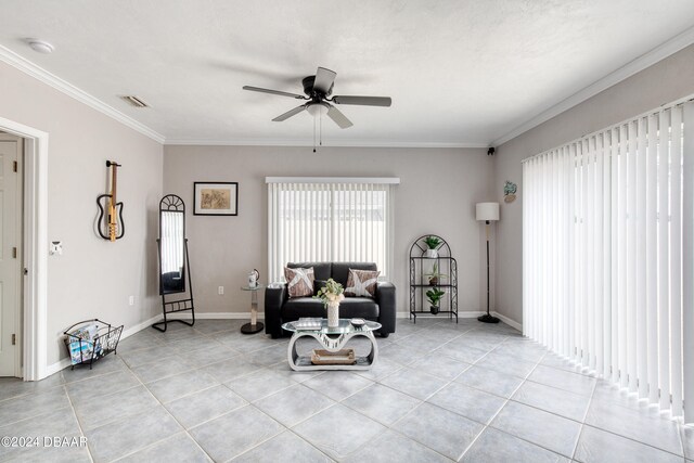 living area featuring ceiling fan, light tile patterned floors, and ornamental molding