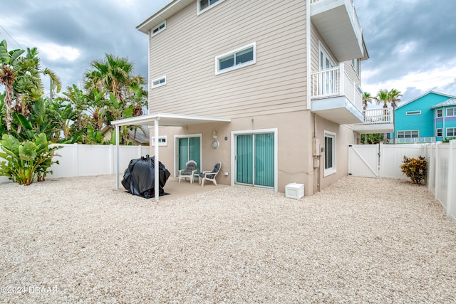 rear view of house with a patio and a balcony