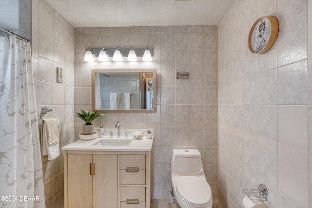 bathroom with vanity, toilet, and tile walls