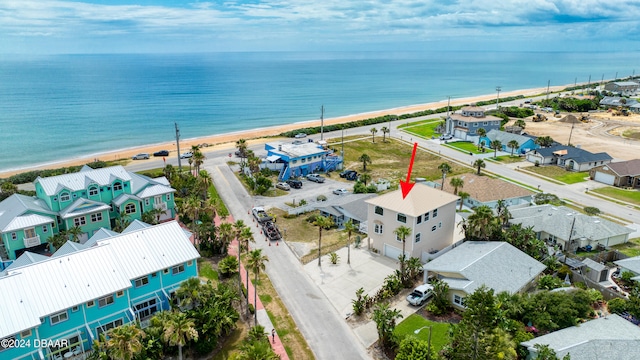 drone / aerial view featuring a water view and a view of the beach