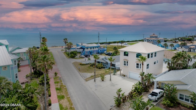 aerial view at dusk featuring a water view