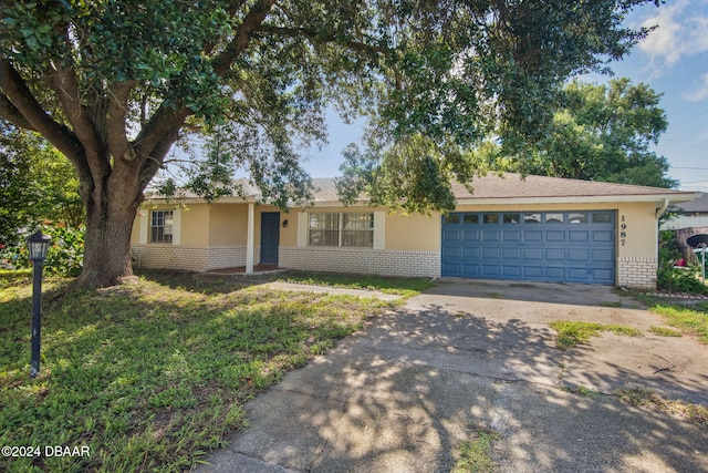 ranch-style home with a garage and a front lawn