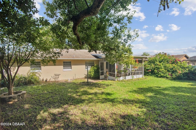 back of property with a sunroom and a yard