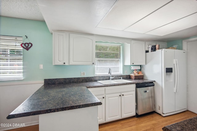 kitchen featuring dishwasher, a healthy amount of sunlight, and white cabinets