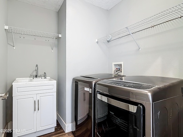 4225 Bristle Cone Way, Port Orange, FL 32129 - washroom featuring washer and clothes dryer, dark wood-style floors, cabinet space, and a textured ceiling