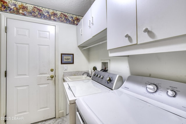 washroom with separate washer and dryer, cabinet space, a sink, a textured ceiling, and marble finish floor