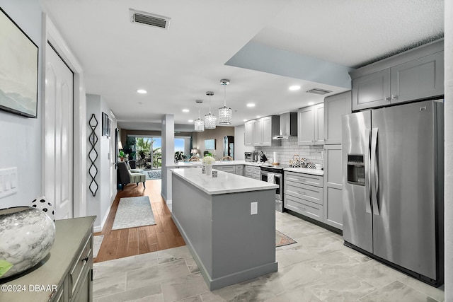 4 Oceans W Blvd Unit 507D, Daytona Beach Shores, FL 32118 - kitchen with appliances with stainless steel finishes, pendant lighting, gray cabinetry, and wall chimney exhaust hood
