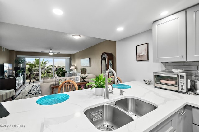 4 Oceans W Blvd Unit 507D, Daytona Beach Shores, FL 32118 - kitchen with light stone counters, white cabinetry, ceiling fan, and sink