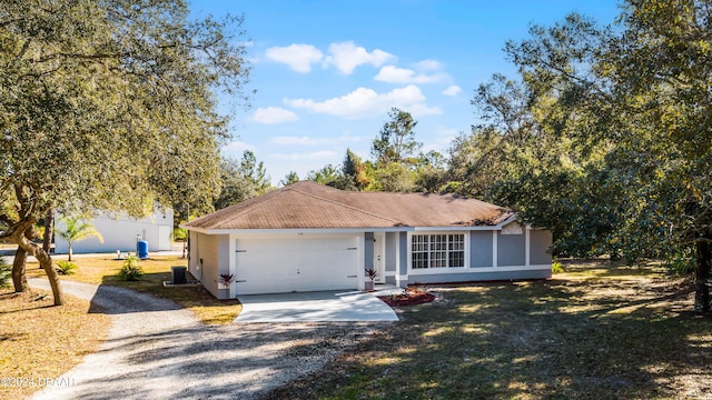 ranch-style home with central AC, a garage, and a front lawn