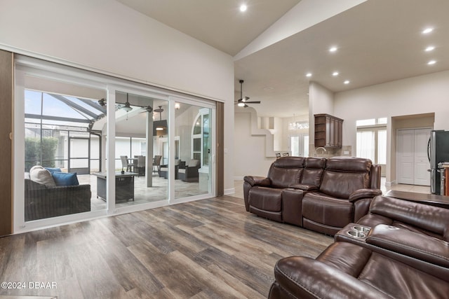 living room with plenty of natural light, wood-type flooring, and lofted ceiling