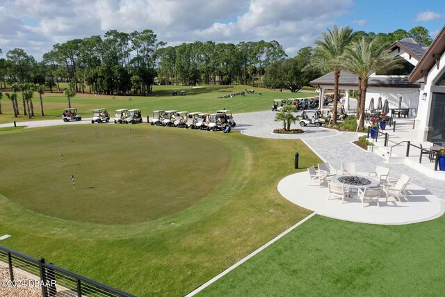 surrounding community featuring a fire pit and a patio area