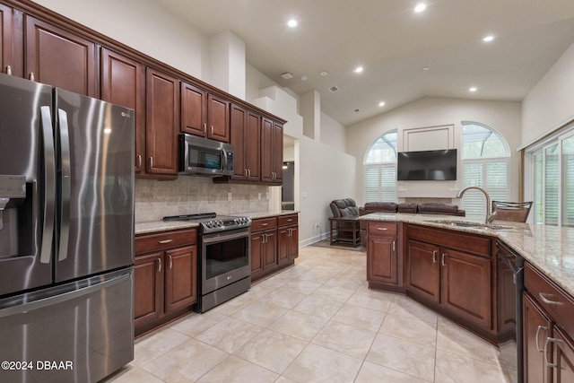 kitchen with light stone countertops, tasteful backsplash, stainless steel appliances, vaulted ceiling, and sink