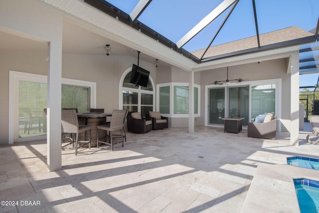 view of patio / terrace with ceiling fan and a lanai