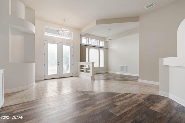 foyer featuring french doors, ceiling fan with notable chandelier, and light hardwood / wood-style flooring